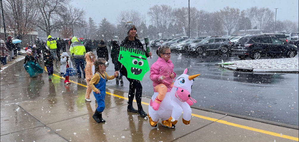 Halloween parade with child in unicorn costume.