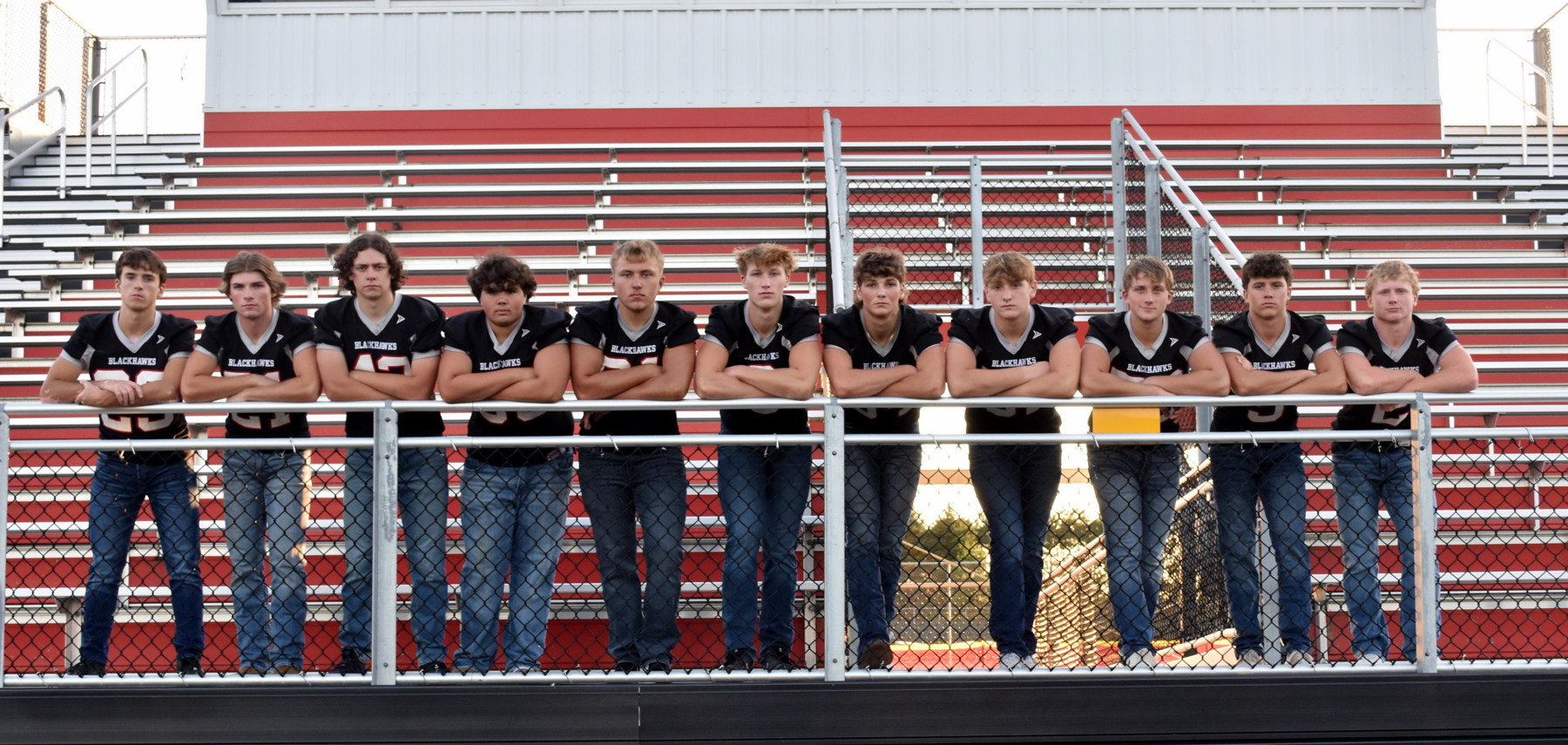 Football players standing on bleachers.