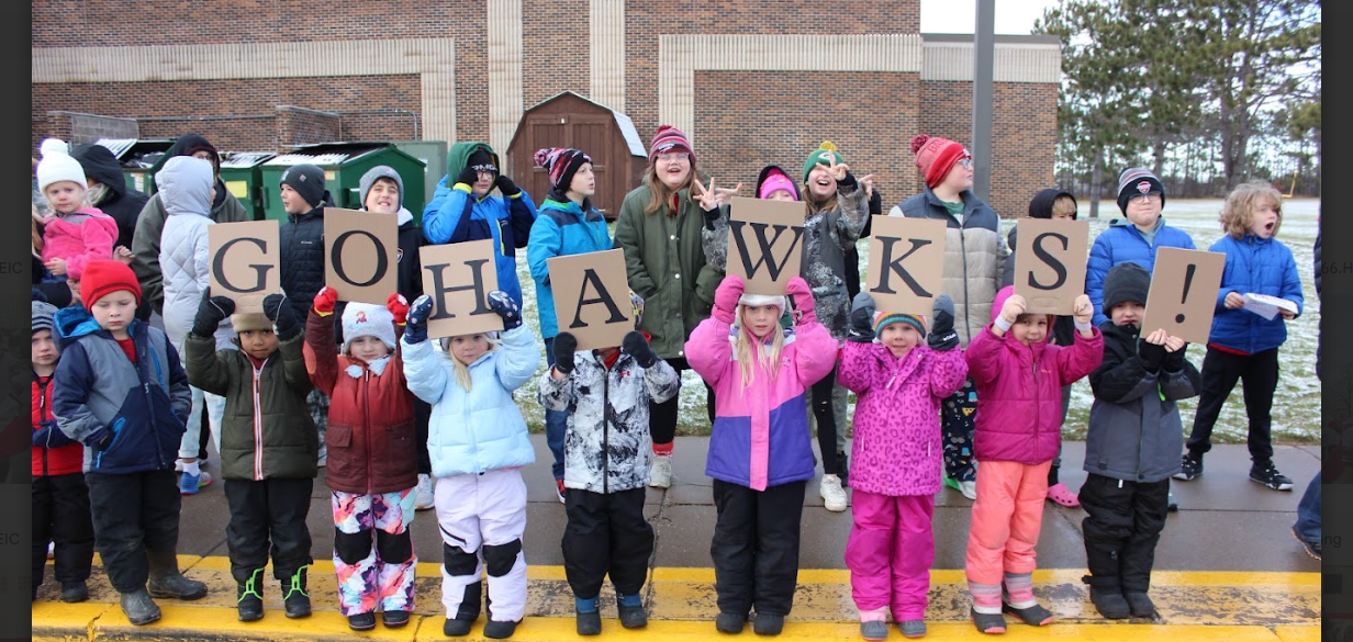 Grade School students holding letters that spell GO HAWKS!